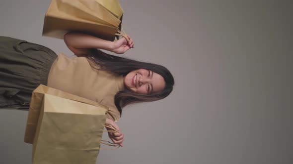 Confident asian woman happy holding shopping bag dancing smilling and looking at camera