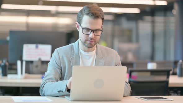 Man with Laptop Smiling at Camera alt