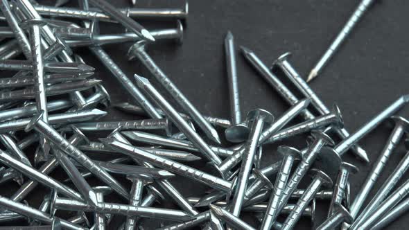 Hand Takes Metal Nails for Construction Work Hobnails are Spinning Close Up Background Pin or Spike alt