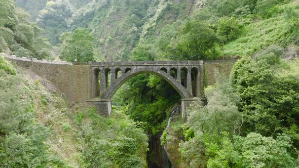 A Ponte Velha ancient bridge, central Madeira; aerial pullback down ravine alt