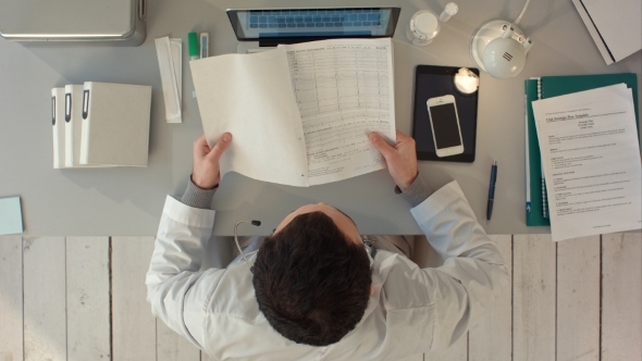 Top View Of Doctors Looking At Cardiogram alt