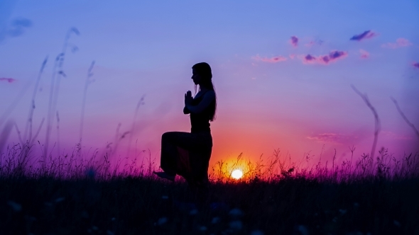 Young Woman Doing Yoga At  Sunset