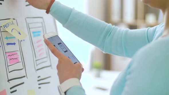 Woman with Smartphone Working on Ui Design alt