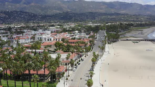 Rising Aerial Pan of Santa Barbara City Near Mountains and Palm Tree Coastline alt