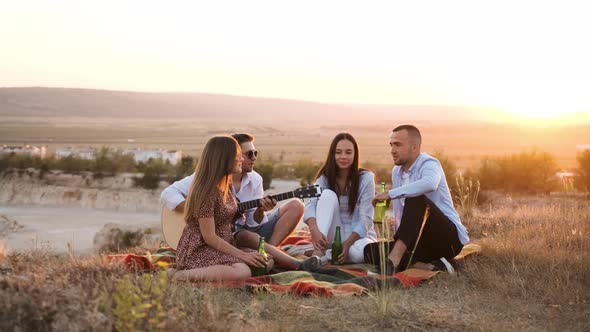 Four Friend Having Fun at Summer Picnic Drinking a Bottle of Beer alt