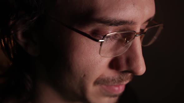 Man in Eyeglasses Late at Night Coder Programmer or Developer Using Laptop in Dark