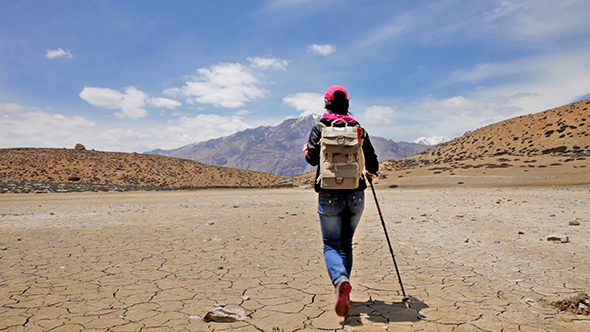 Woman Traveler Walks On A Dry Mountain Lake alt