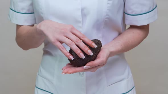 Nutritionist Doctor Healthy Lifestyle Concept - Holding Organic Avocado alt