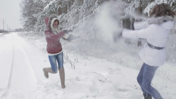 People Playing in the Snow in the Woods