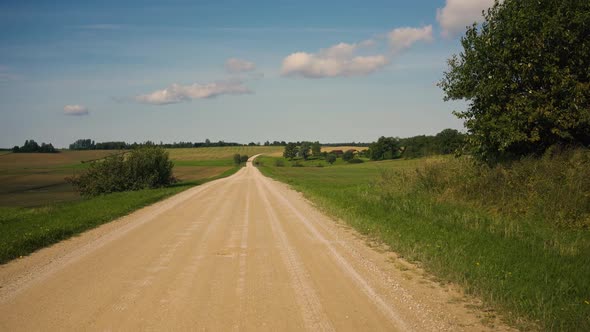 Yellow gravel road through the fields of Latvia