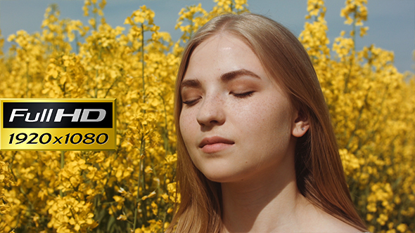 Cute Girl Smiling For The Sun At Field Full Of Yellow Flowers alt