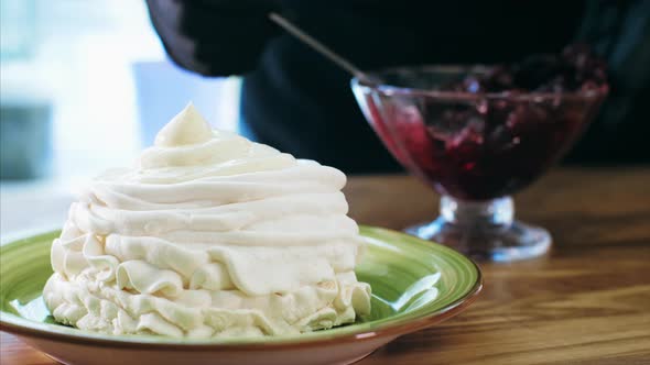 Chef Cooking Meringue Cake with Cream and Cherry Jam. alt