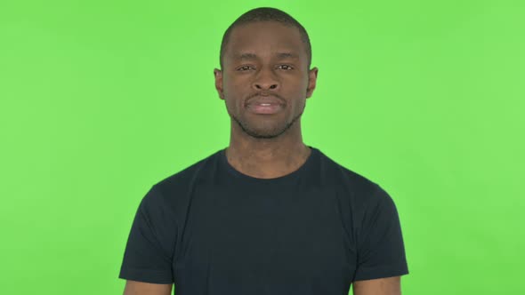 Serious Young African Man on Green Background alt