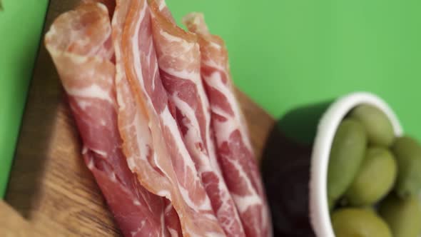 Vertical video, Close-up: cold cuts, salami, prosciutto, jamon, cherry tomatoes, sliced ​​sausage alt