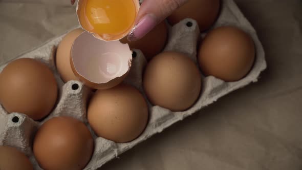 Woman's Hand Pours Chicken Yolk From One Half of the Scarloop to the Other alt