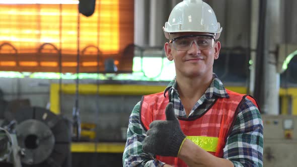 Confident engineer foreman in arms crossed showing thumbs up to camera