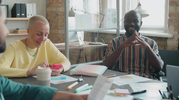 Afro Man in Wheelchair Talking with Business Team at Office Meeting alt