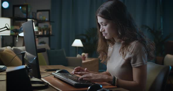 Young woman sitting at desk and connecting with her computer