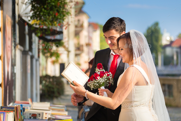 Beautiful wedding couple reviewing vintage books.
