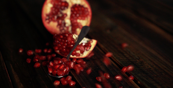 Pomegranate Clusters Falling On Wooden Table alt