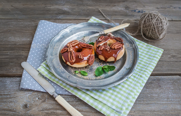 Cinnamon donuts with caramel icing and pekans served with fresh - Stock Photo - Images