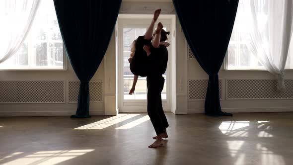 Young Dancer Man is Lifting His Female Partner on Hands Dancing and Rehearsing in Dance Hall alt