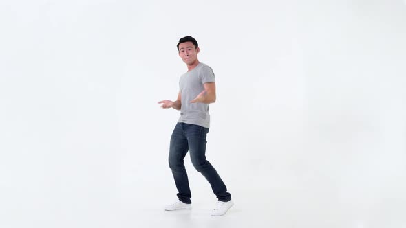 Full body of cute Asian man making funny dancing movement isolated on white background