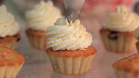 Whipped Cream Frosting Applied To Berry Cupcakes