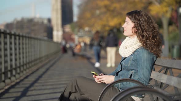 A Beautiful Woman Seated On A Bench Near The Brooklyn Bridge 5 alt