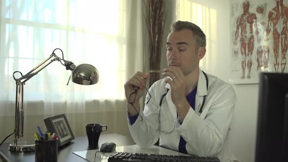 Stressed Doctor Working At His Office Desk 5 alt