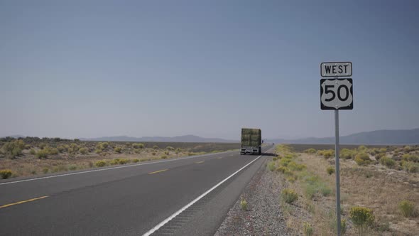 Big Rig Tractor Drives Along A Road In The Desert 2 alt