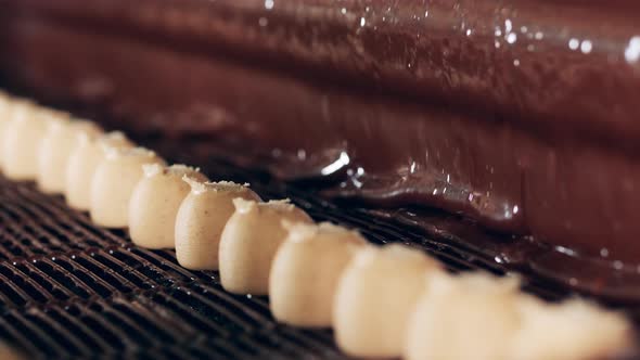 Liquid Chocolate is Covering Fudge Sweets During Transportation alt