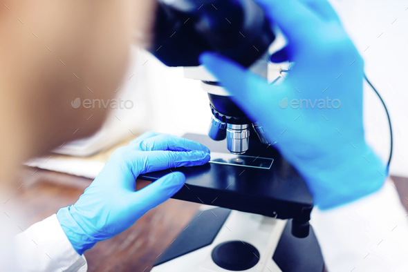 Scientist using microscope to examin small chemical probes. Medical ...