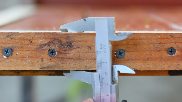 Carpenter Measuring Wooden Detail With Calipers