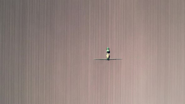 Top down view of farming tractor spraying on field. Protection of plants. alt
