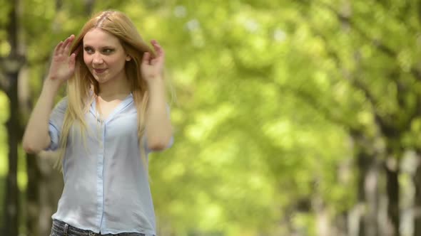 Young Beautiful Blonde Girl Portrait in Summer Day at Urban City Park