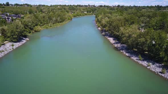 Drone flying over a beautiful river on a sunny day in the city. alt