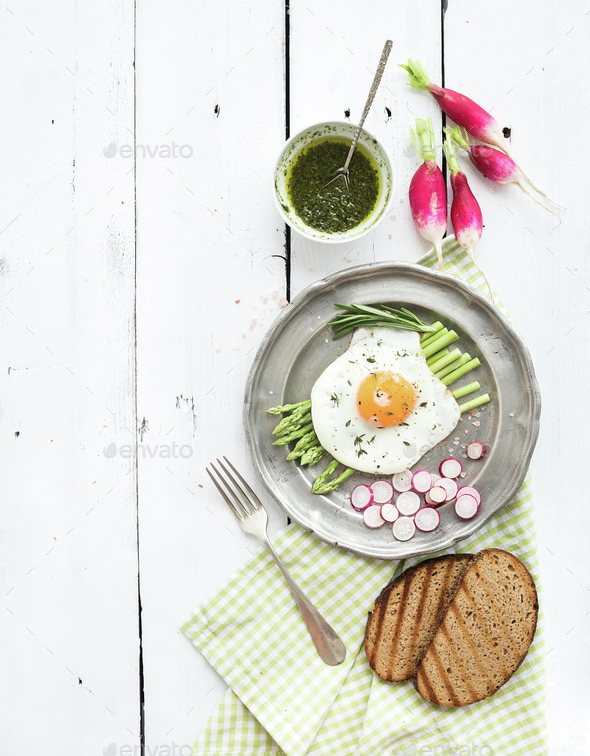 Healthy breakfast set. Fried egg with asparagus, radishes, green sauce and bread - Stock Photo - Images