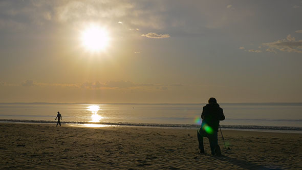 Person Filming the Sunrise on a Beach