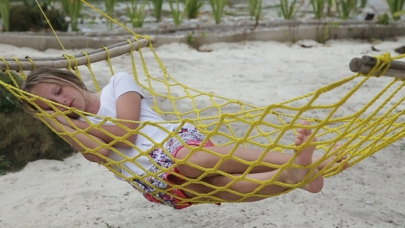 Young Girl Relaxing In a Hammock On The Sea Beach alt