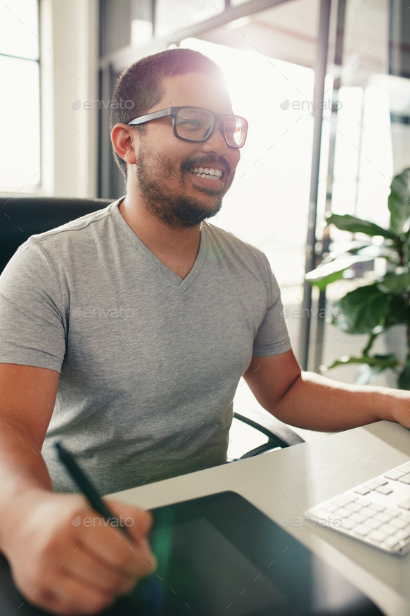 Happy graphic designer working in his office - Stock Photo - Images