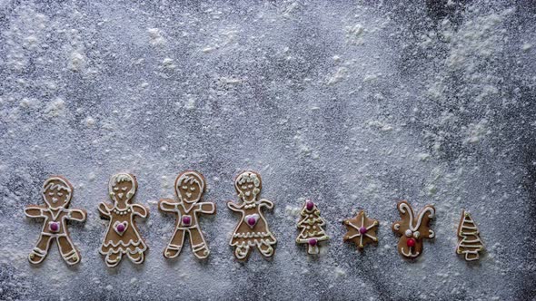 Christmas baking decorations  - gingerbread characters stop motion on white flour background