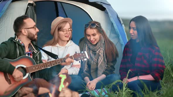 Joyful Male Guitarist Play During Relaxed People Sing alt