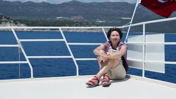 Tourist Woman Sunbathing on Upper Deck of Yacht. Red Flag on Turkey. On the Way To Famous Kekova alt
