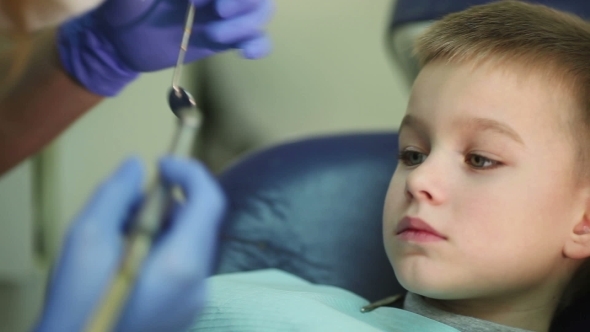 Little Kid During Procedure Of Teeth Drilling Treatment