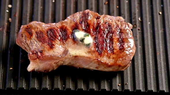 Grilling Steak With a Piece of Melting Butter