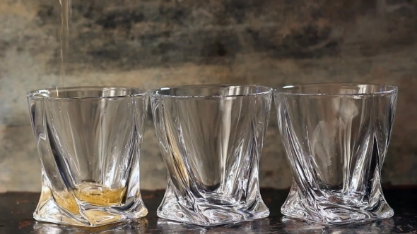 Pouring Whiskey In Three Glasses