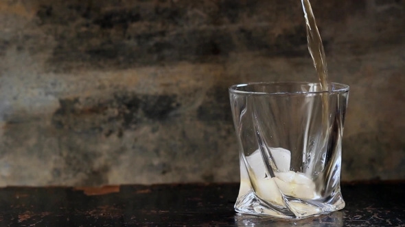 Pouring Whiskey In Glass With Ice
