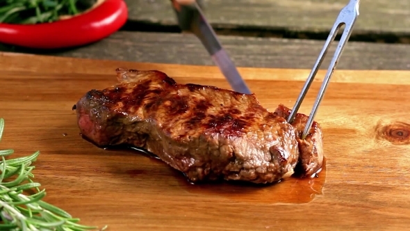 Slicing Of Grilled Steak On a Cutting Board