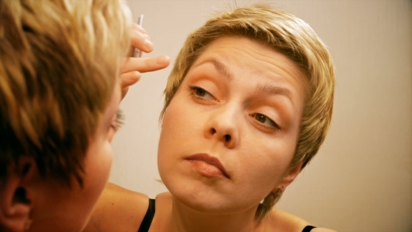 Woman Plucks And Pulls Her Eyebrows Out At Mirror